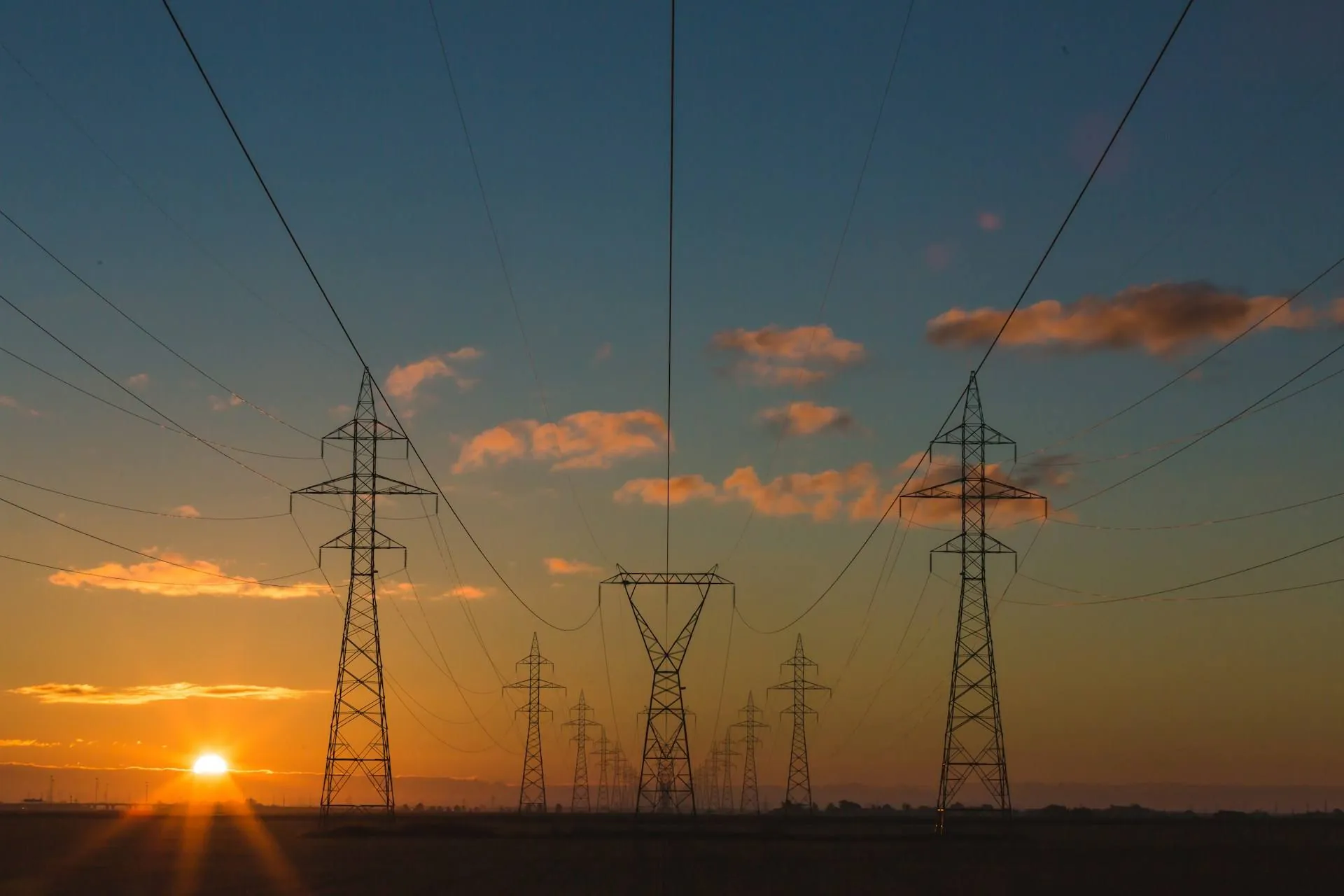 Telecom towers silhouetted against sunset sky